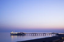 England, East Sussex, Brighton, View of the pier at sunset from the seafront promenade in Kemptown.