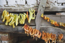 Turkey, Aydin Province, Sirince, Strings of chilies hanging up to dry in late afternoon summer sunshine against wooden window frame of building in the old town.   