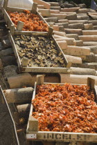 Turkey, Aydin Province, Sirince, Shallow wooden crates of chilies and mushrooms drying in late afternoon summer sunshine on tiled rooftops of house in the old town.   