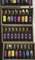 Turkey, Aydin Province, Kusadasi, Sirince fruit wines produced locally, displayed in wooden crates outside shop.