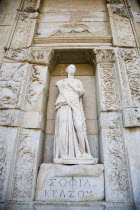 Turkey, Izmir Province, Selcuk, Ephesus, Statue set in alcove of ornately carved wall in ancient ruined city of Ephesus on the Aegean sea coast.