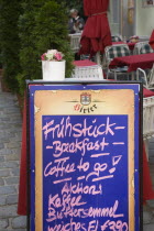 Austria, Vienna, A board sign outside courtyard cafe advertising breakfast menu.  