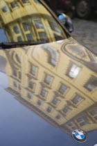 Austria, Vienna, Building facade reflected in bonnet and windscreen of BMW car.  