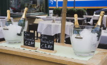 Austria, Vienna, The Naschmarkt, Ice buckets with bottles of sparkling Riesling on side table in upmarket outdoor restaurant: 