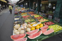 Austria, Vienna, The Naschmarkt, Display of fresh fruit for sale on stall outside shopfront including apples, melon and pineapple.