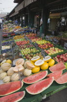 Austria, Vienna, The Naschmarkt, Display of fresh fruit for sale on stall outside shopfront including apples, melon and pineapple.