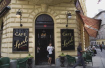 Austria, Vienna, Mariahilf District, Cafe Sperl, the preferred cafe of Adolf Hitler. Exterior facade with waitress carrying coffee order at entrance. Striped awning pulled out at side with customers s...