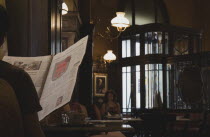 Austria, Vienna, Mariahilf District, Cafe Sperl, the preferred cafe of Adolf Hitler, interior with person reading a newspaper in foreground and a female customer sitting reading on her own beyond. Ove...