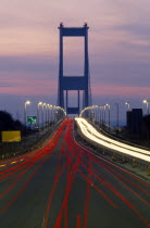 England, Bristol, Severn Bridge at night with streaked lights from traffic.