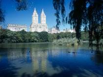 USA, New York, Manhattan, Central Park West, view over lake toward the San Remo twin towered building.