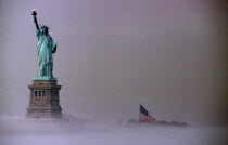 USA, New York, Liberty Island, Statue of Liberty and Ss Flag on misty morning.