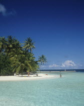 Maldives, Beach with tourist sunbathing and swimming in the Indian Ocean.