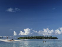 Maldives, Beach with tourist sunbathing and swimming in the Indian Ocean.