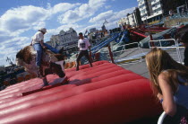 England, East Sussex, Brighton, Tourist on Seafront Bucking Bronco Ride