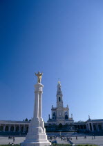 Portugal, Beira Litoral, Fatima, Golden Statue of Christ with church in the background.
