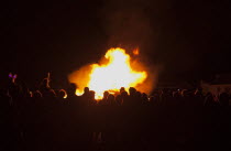 Festivals, Guy Fawkes, Bonfire, People silhouetted by flames from fire on the beach.