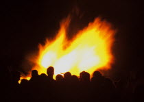 Festivals, Guy Fawkes, Bonfire, People silhouetted by flames from fire on the beach.