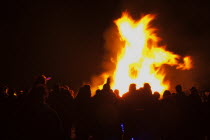 Festivals, Guy Fawkes, Bonfire, People silhouetted by flames from fire on the beach.