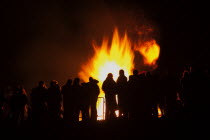 Festivals, Guy Fawkes, Bonfire, People silhouetted by flames from fire on the beach.