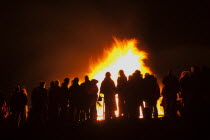 Festivals, Guy Fawkes, Bonfire, People silhouetted by flames from fire on the beach.