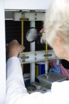 Climate, Weather, Measurements, Female weather observer using a magnifying glass to take readings from the dry-bulb thermometer which measures relative humidity in the Stevensons Screen cabinet at Bog...