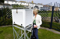 Climate, Weather, Measurements, Female observer beside a Stevensons screen cabinet which holds various thermometers for measuring minimum and maximum temperatures and relative humidity at the Bognor R...