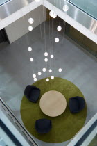 Ireland, County Dublin, Dublin City, Ballsbridge, Lansdowne Road, Aviva Stadium interior stairwell with table and chairs on carpet beneath chandelier in the President's suite area.