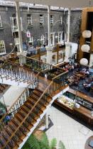 Ireland, County Dublin, Dublin City, Powerscourt Centre restaurants with people at tables beside shops in the enclosed old Georgian townhouse courtyard.