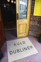 Ireland, County Dublin, Dublin City, Entrance door to the Auld Dubliner pub in Temple Bar with the name written on the ground.