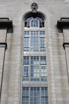 Ireland, County Dublin, Dublin City, Department of Industry and Commerce Government building in Kildare Street showing a head popping out of the top of the building representing Eire Art Deco with som...