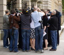 Ireland, County Dublin, Dublin City, News Media Press photographers cameramen and journalists surrounding a politician on the pavement sidewalk outside the Irish Parliament buildings.