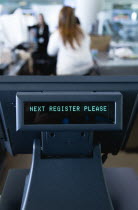 Ireland, County Dublin, Dublin City, Ballsbridge, Lansdowne Road, Aviva Stadium Unattended cash register with a digital readout that says Next Register Please with people in the background.