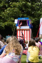 Children, Entertainment, Punch and Judy Show, Children sitting on grass watching the traditional puppet show.