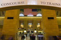 USA, New York, Manhattan, Grand Central Terminal railway station entrance to the Main Concourse from the Vanderbilt Hall with people walking below the American Stars and Stripes flag hanging from the...