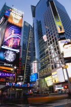 USA, New York, Manhattan, People walking at night in Times Square at the junction of 7th Avenue and Broadway by the New York Police Department station below buildings with advertising on large video s...