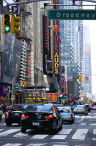 USA, New York, Manhattan, Cars crossing Broadway at green traffic lights travelling east along 42nd Street past the New Amsterdam Theater and Madame Tussauds.