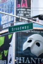 USA, New York, Manhattan, Overhead road sign for Broadway with theatre stage show posters or billboards on buildings beyond.