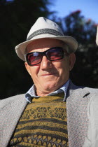 Albania, Tirane, Tirana, Head and shoulders full face portrait of a middle-aged man wearing a hat and sun-glasses.