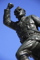 Albania, Tirane, Tirana, Statue of the Unknown Partisan. Part view from below, looking upwards, against blue sky.