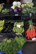 Albania, Tirane, Tirana, Display of fruit and vegetables at grocers stall in the Avni Rustemi Market including aubergines, cabbage and carrots.