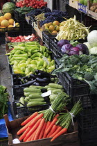 Albania, Tirane, Tirana, Grocers fruit and vegetable shop front in the Avni Rustemi market with display including grapes, cabbage, peppers, aubergine and carrots.