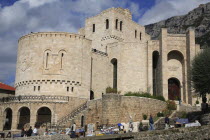 Albania, Kruja,  Kruja Castle and Skanderbeg Museum exterior with tourist visitors and souvenir stalls in foreground.