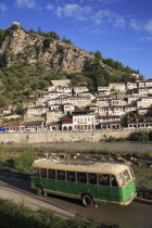 Albania, Berat, Traditional Ottoman buildings and river Osum with  local bus in foreground.