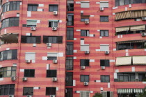 Albania, Tirane, Tirana, Colourful apartment building with shuttered windows and air conditioning units.