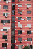 Albania, Tirane, Tirana, Colourful apartment building with shuttered windows and air conditioning units.
