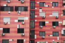 Albania, Tirane, Tirana, Colourful apartment building with shuttered windows and air conditioning units.