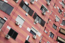 Albania, Tirane, Tirana, Colourful apartment building with shuttered windows and air conditioning units.