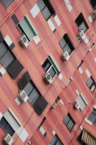 Albania, Tirane, Tirana, Colourful apartment building with shuttered windows and air conditioning units.