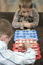 Children, Playing, Indoor, Two young boys playing a game of GuessWwho together.