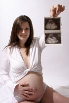 Health, Maternity, Pregnancy, A proud mum to be showing off her ultrasound scan photograph.